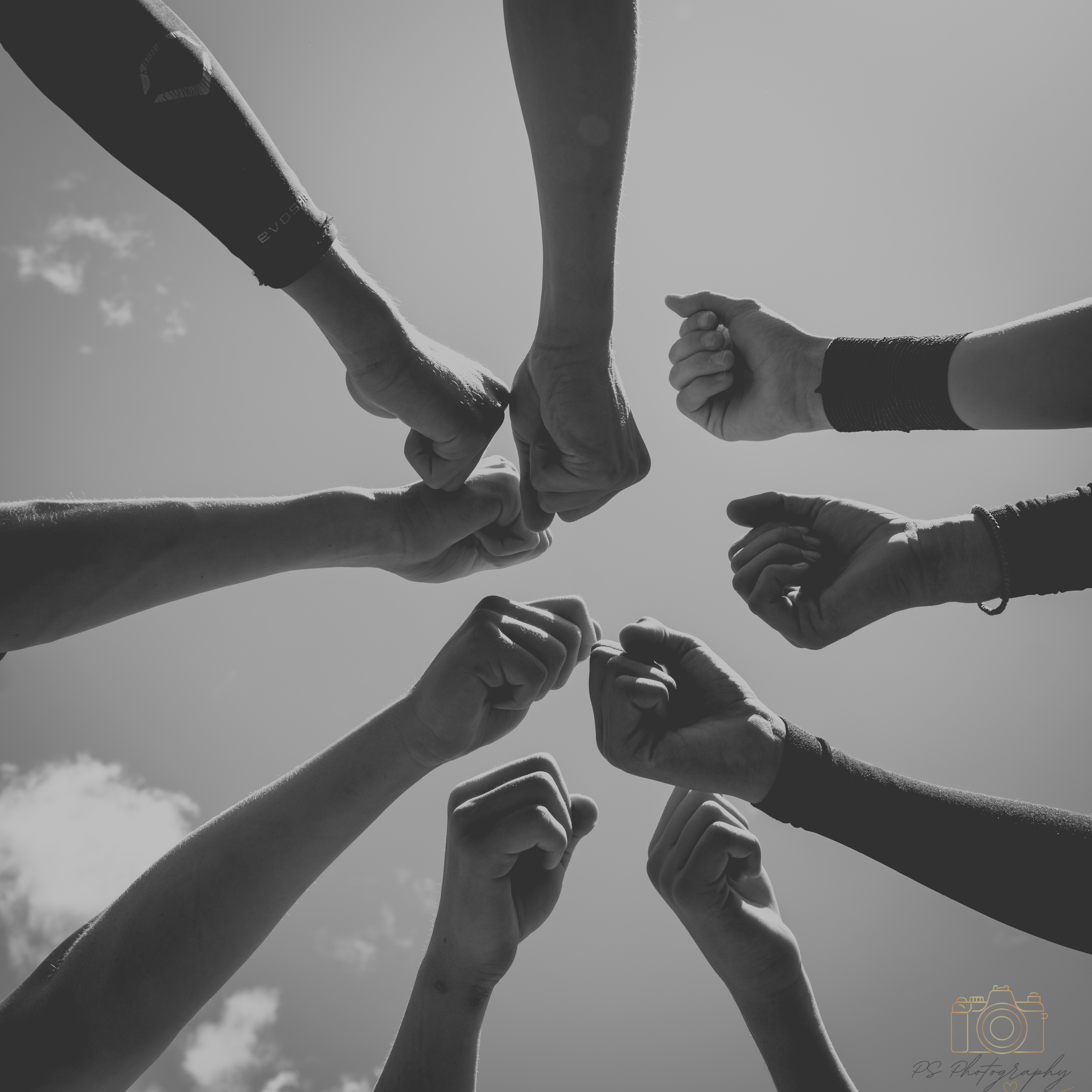 Black and white photo of athletes putting their fists together before a game