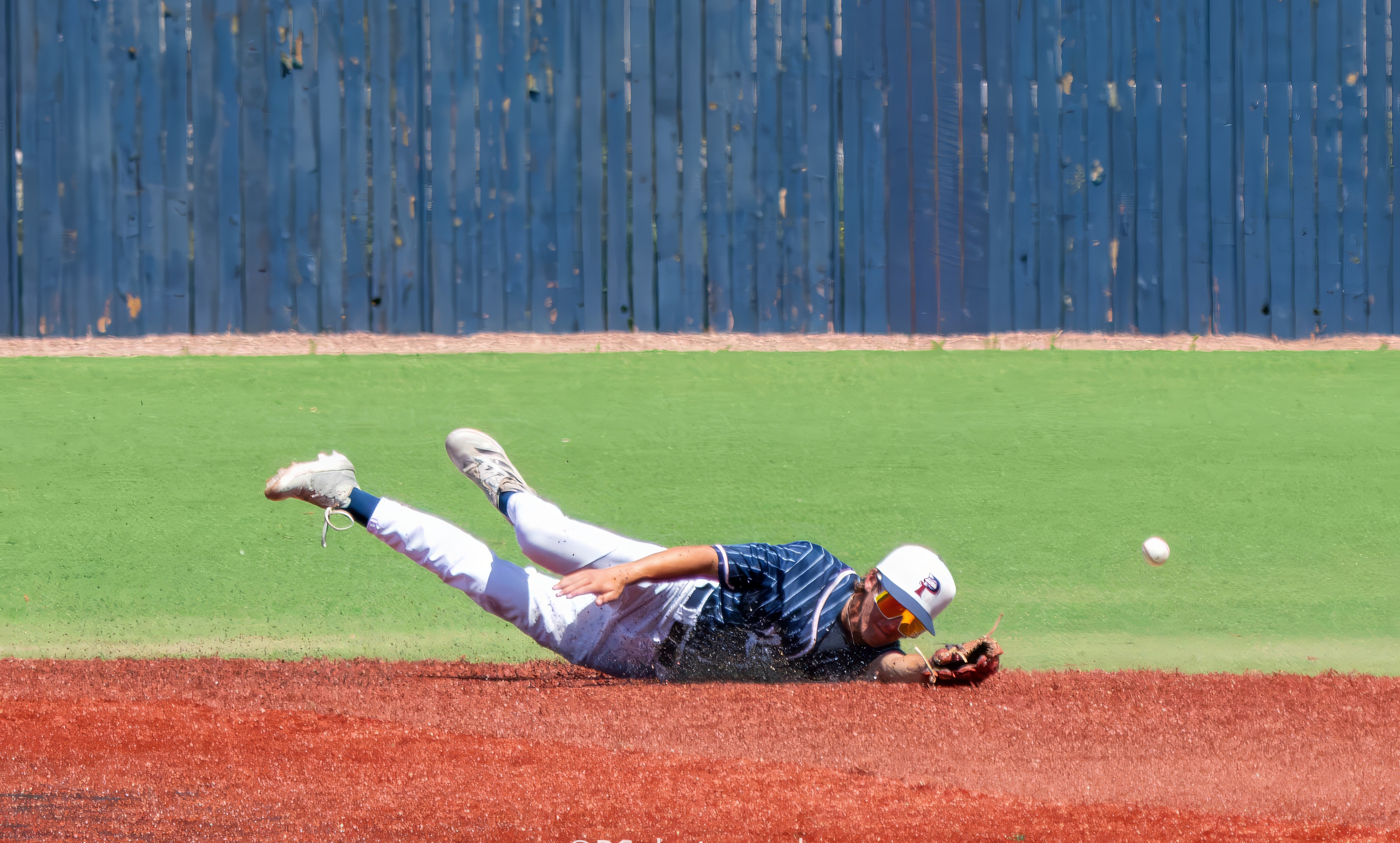 Baseball player diving across the infield for the ball