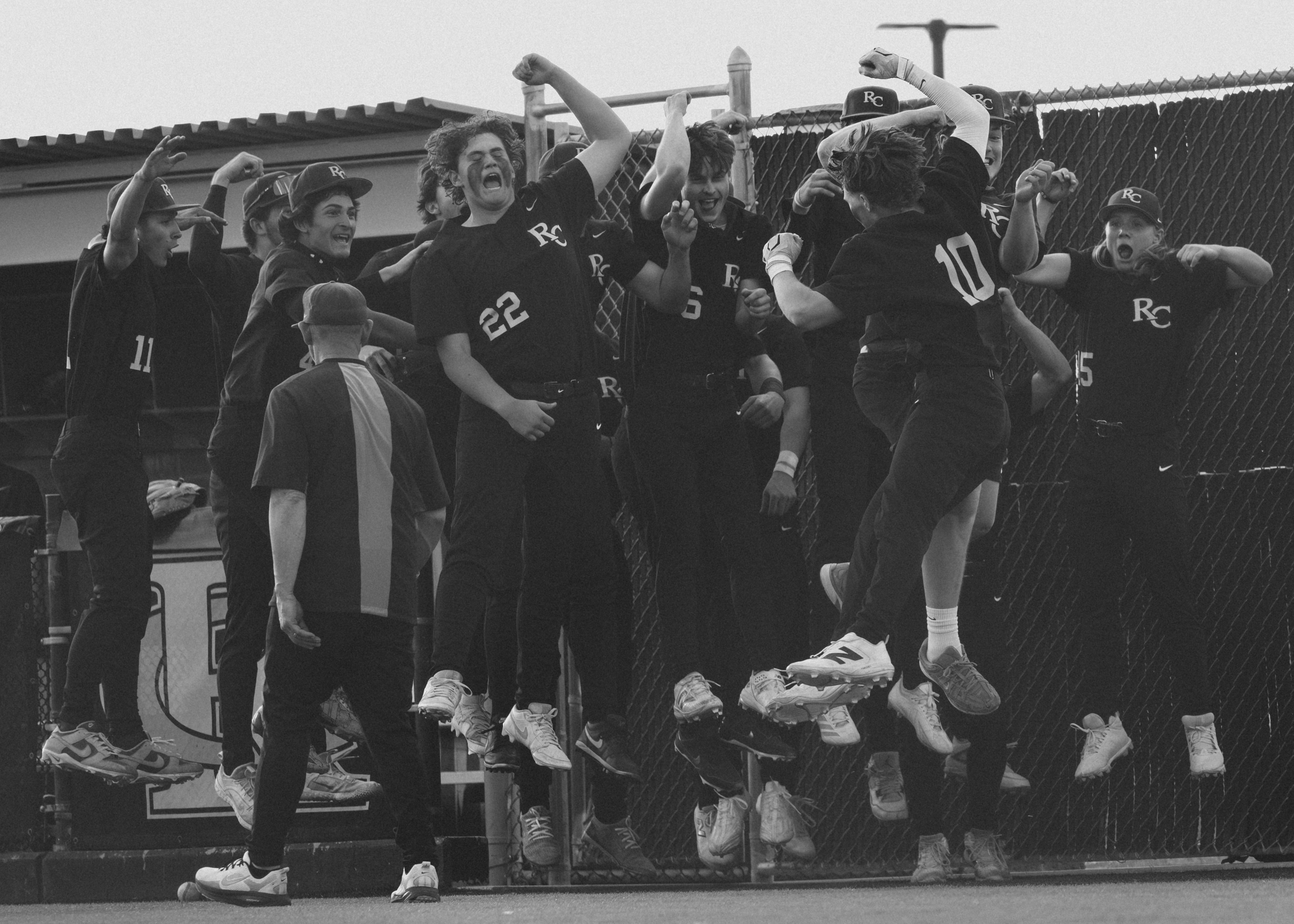 Baseball team celebrating at the dugout during a game