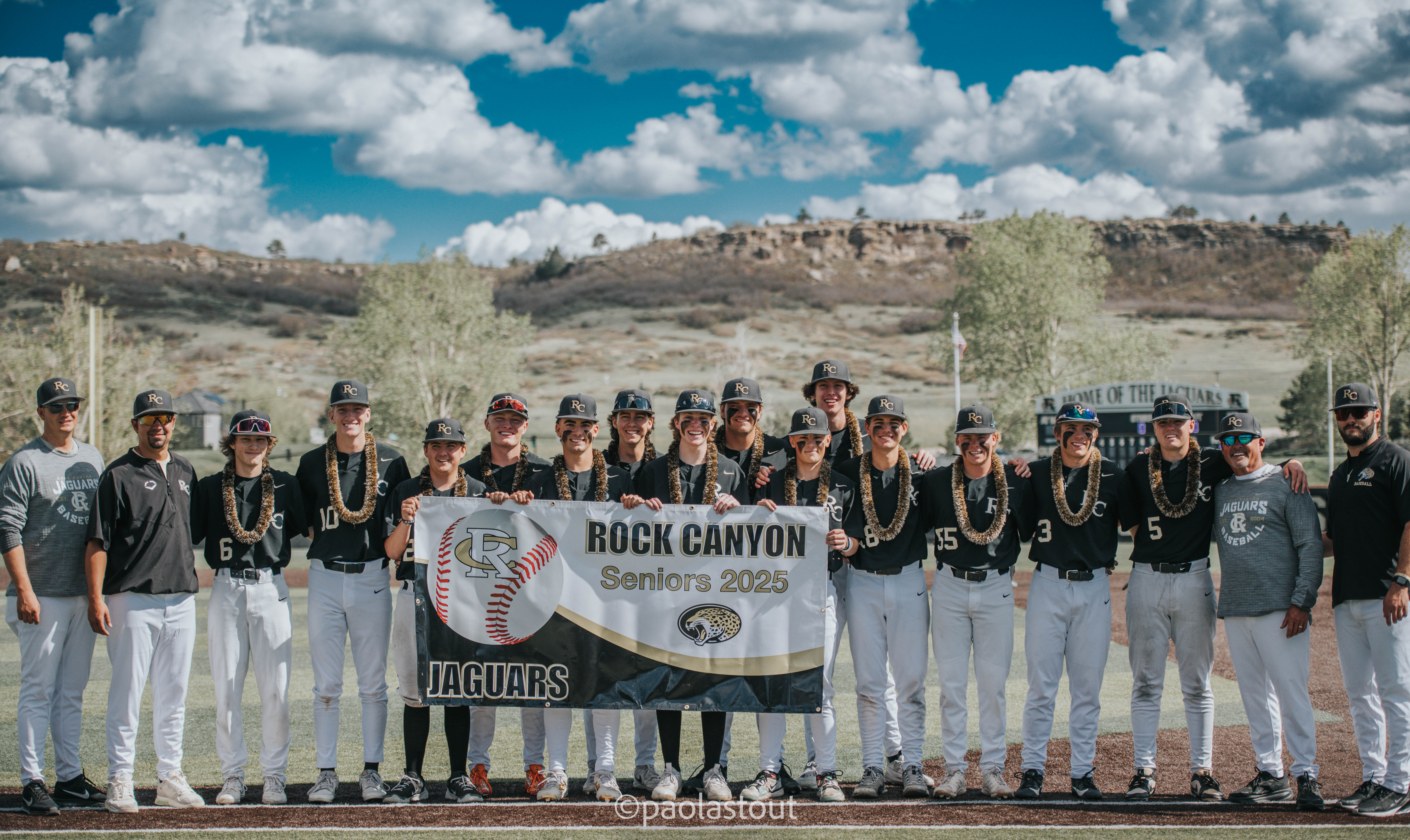 Rock Canyon senior baseball players standing with a Seniors 2025 banner