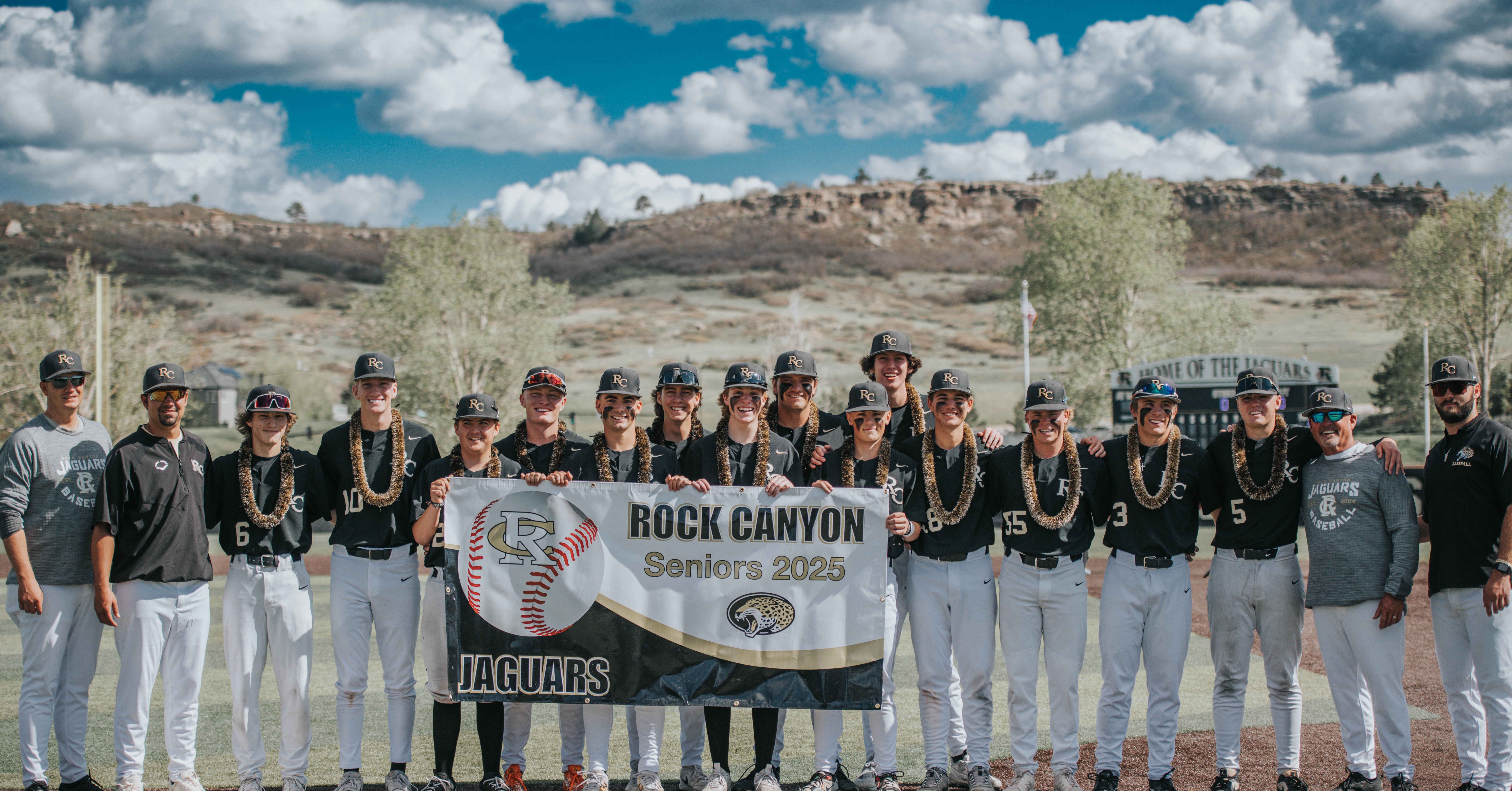 Rock Canyon senior baseball players standing with a Seniors 2025 banner